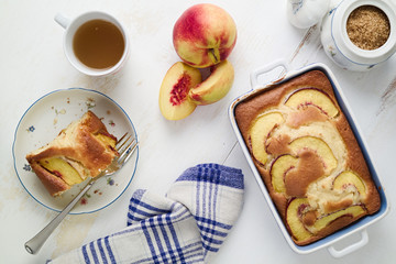 Diet yogurt sponge cake with peaches on table. Homebaked food.
