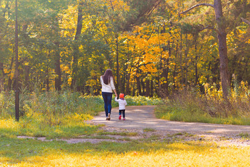 Fototapeta premium Young mother walking with her baby in an autumn park
