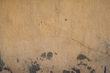 Texture of old wall covered with yellow stucco