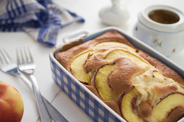Homemade diet sponge cake with nectarines in blue ceramic dish