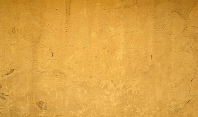 Texture of old wall covered with yellow stucco