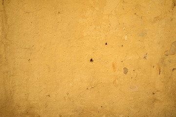 Texture of old wall covered with yellow stucco