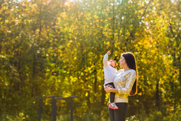 Young mother walking with her baby in an autumn park