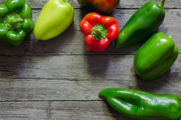 Green and red pepper on wooden background
