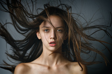 Closeup beauty portrait of a sexy brunette girl with flying hair