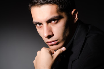 Young businessman in dark studio