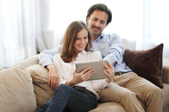 Cheerful couple using tablet
