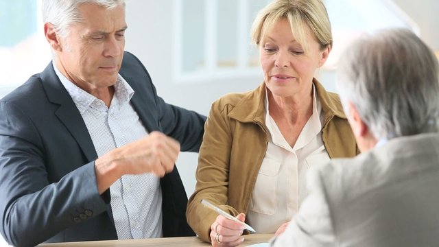 Senior couple meeting real-estate agent for investment