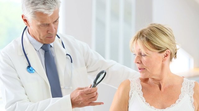 Elderly woman consulting doctor for skin control