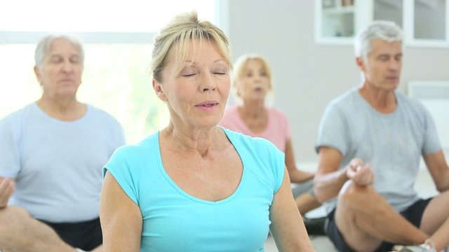 Group of senior people doing yoga exercises