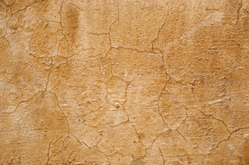Fototapeta na wymiar Texture of old wall covered with yellow stucco