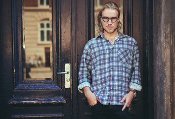 Portrait of a smart serious young man standing against building