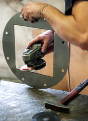 Metalworker sanding a metal component