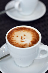 Delicious foamy cappuccino on the black background