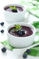 Delicious blueberry mousse in bowls on wooden table