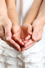 Adult hands holding kid hands
