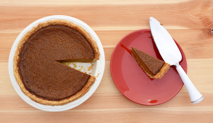 Slice taken from a pumpkin pie with pie server