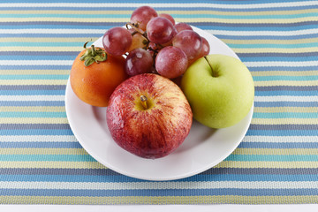 grape, tomato, apple and yellow measuring tape concept for healt