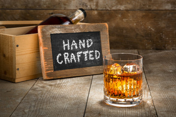 Hand crafted small batch craft liquor glass bourbon whisky scotch brandy rum on wooden rustic...