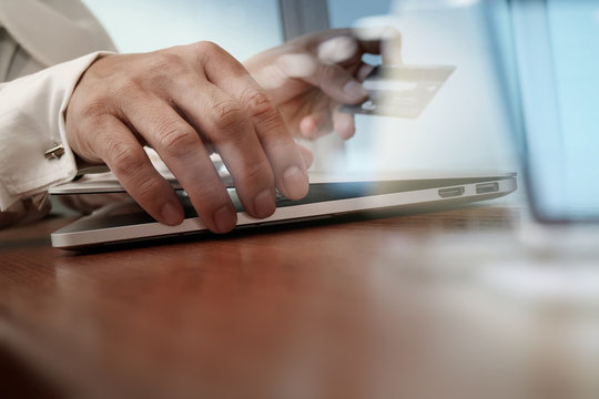 close up of hands using laptop and holding credit card as Online
