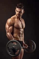 Fototapeta na wymiar Muscular bodybuilder guy doing exercises with big dumbbell dumbb