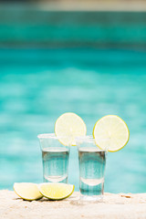 Tequila shots with lime on blue background