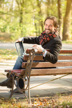 Middle-aged man resting on the bench outdoors