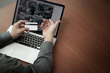 top view of hands using laptop and holding credit card with soci