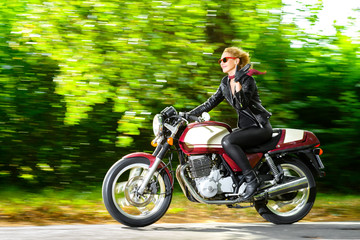 Fototapeta na wymiar Active girl riding on the motorbike, slow motion, having fun in