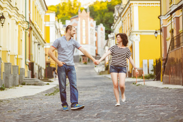 Naklejka premium Happy couple in love walking at city. Warm toned photo