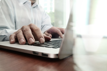 Fototapeta premium close up of business man hand working on laptop computer on wood