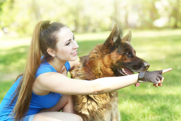 Beautiful young girl with dog in park