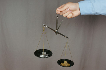 Hand holding scales with coins