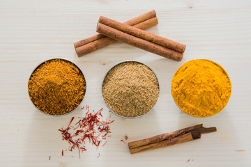 coriandolo, paprika, cannella, zafferano e cardamomo su legno