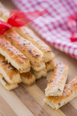 Bread Salty Sticks with sesame and flax seeds prepared for New Year's Day with red ribbon and red Christmas decorations