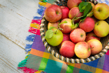 Organic apples in basket, on white vintage wooden background, fresh homegrown produce