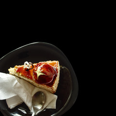 Delicious piece of cake on isolated black background