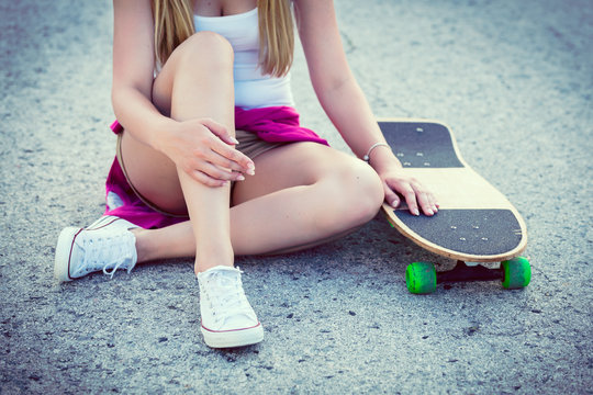 Anonymous hipster teenage girl with skateboard