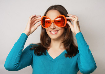 Playful young woman with big party glasses.