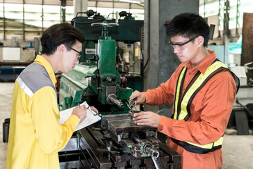 Asian Mechanical Engineer checking equipment in factory

