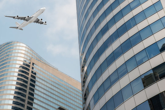 Shot of airplane flying above skyscrapers in City of Bangkok downtown.