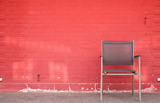 Chair And Lamp Against Brick Wall