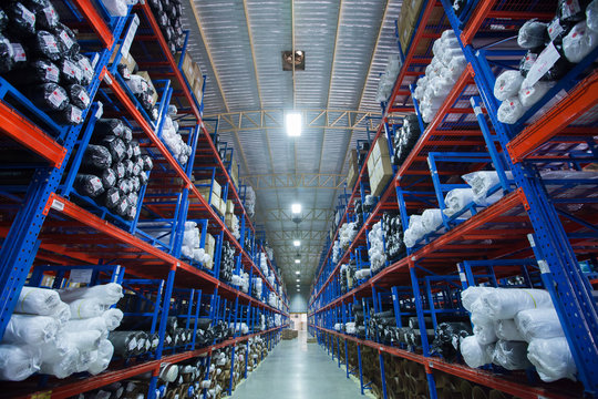 Rows of shelves with boxes in modern warehouse