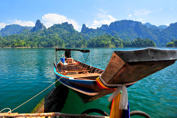 Obraz premium Wooden pier on the lake in the jungle. Wooden boats of Thailand with the reflection in the water.