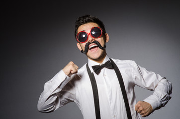 Fototapeta premium Young caucasian man wearing sunglasses against gray