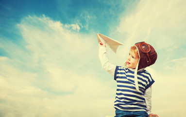 Happy child dreams of becoming pilot aviator and plays with plan