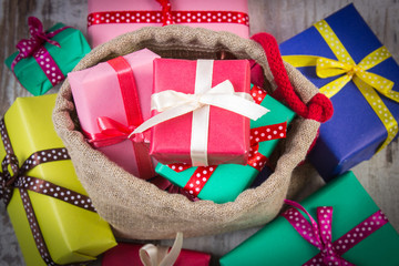 Heap of wrapped gifts for Christmas or other celebration on old wooden plank