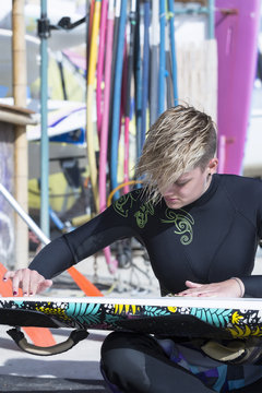 windsurfer girl preparing a windsurf board