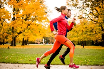 Muurstickers Couple jogging in autumn nature © Martinan