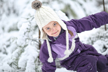 Fototapeta na wymiar Young girl fooling around in the snow in frosty day